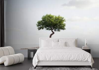 A tree with its roots wrapped in chains, unable to grow. Wall mural