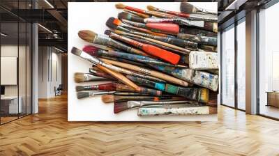 A collection of old paintbrushes on a white background, viewed from above. A creative and artistic concept featuring numerous colorful artist's brushes Wall mural