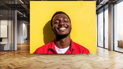 Black Man in Red Shirt and White T-Shirt, Laughing Joyfully on a Sunny Day, Close-Up Portrait with Sunlight and Yellow Wall Backdrop
 Wall mural