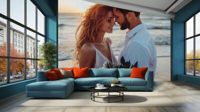 Close-up portrait of a joyful young couple at sunset on the beach, the red-haired woman with freckles holding flowers, both in white, embodying romance and love on a special occasion. Wall mural