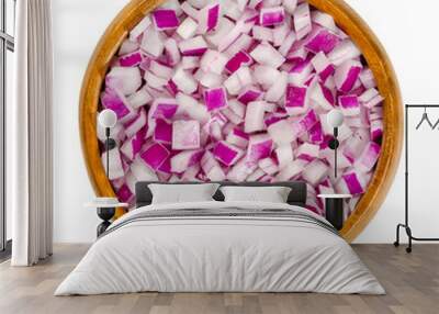 Diced red onions in wooden bowl. Cut cubes of onion cultivar Allium cepa, with purplish red skin and white flesh tinged with red. Closeup, from above, on white background, isolated, macro food photo. Wall mural