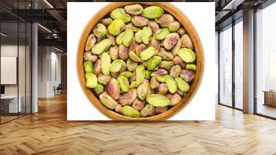 Shelled pistachio kernels in wooden bowl. Dried seeds and ripe fruits of Pistacia vera. Snack. Isolated macro food photo close up from above on white background. Wall mural