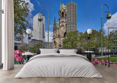 berlin germany, The Kaiser Wilhelm Memorial Church, in GermanKaiser-Wilhelm-Gedächtniskirche, spring time in the city, with a blue sky and colourful flowers, green trees on the road side Wall mural