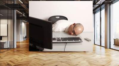 A businessman asleep at his desk. Wall mural