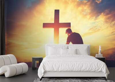 Silhouette of a Man Kneeling in Front of a Cross at Sunset with Copy Space for Easter or Christian Theme Background, Photorealistic Wall mural