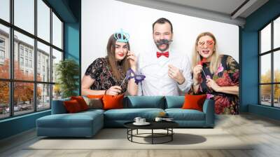 three people girls man posing party props photo booth white plain background studio hat Wall mural