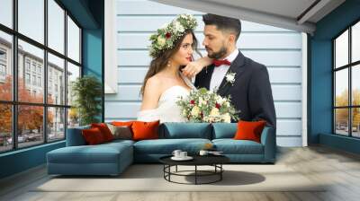 young couple bride groom getting married wedding posed photos at seaside sea beach hairpiece flowers bouquet church Wall mural