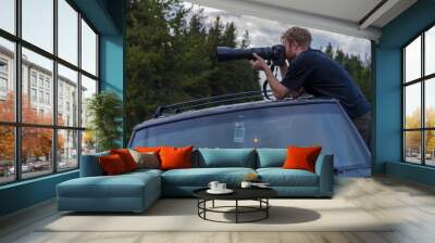 young man with camera taking photos  Wall mural