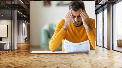 Man overwhelmed by bills and past-due notices, debt stress, financial burden Wall mural