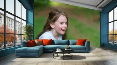 Little beautiful girl on the background of the road in the park. Happy childhood concept outdoors Wall mural