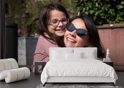 Portrait of happy mother and daughter in sunglasses having fun outdoors. Wall mural