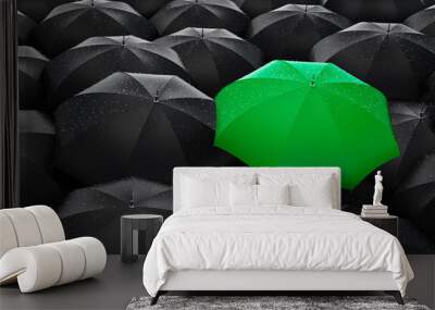 Green umbrella stand out from the crowd of many black umbrellas - being different concept Wall mural