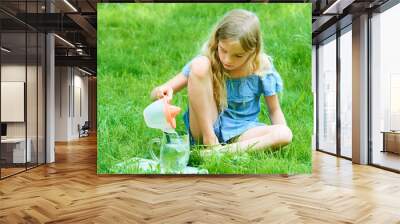 Little adorable child girl preparing fresh lemonade while sitting on grass Wall mural