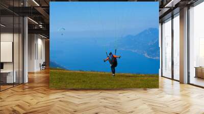 Paraglider flying over the Garda Lake (Lago di Garda or Lago Benaco). Paragliding on Monte Baldo. Panorama of the gorgeous Garda lake surrounded by mountains, Malcesine, Italy Wall mural