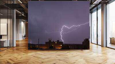 lightning over buildings at night Wall mural