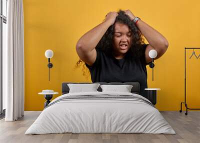 Disappointed afro-american with overweight woman keeping hand on had, headache over isolated orange background wearing fashion black shirt. People lifestyle concepte. Wall mural