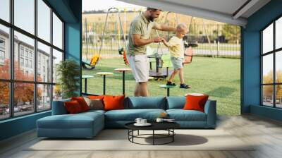 Father with son having fun on the playground Wall mural