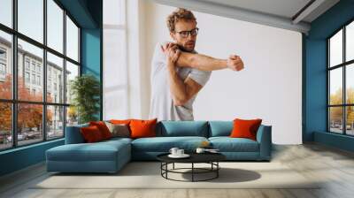 Man practicing yoga on the mat at home Wall mural