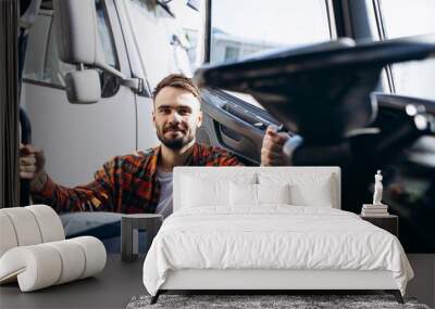 Man trucker driving in a cabin of his truck Wall mural