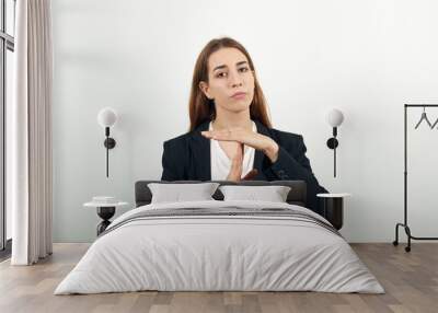 Time out gesture, break, doing t symbol or sign with help of hands. Young attractive woman with brown hair in a light t-shirt and black jacket on white background Wall mural