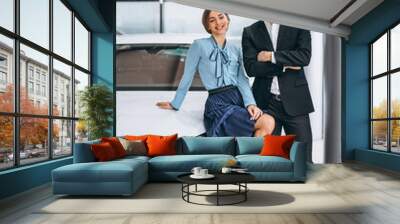 Two female and male salesperson at a car showroom Wall mural