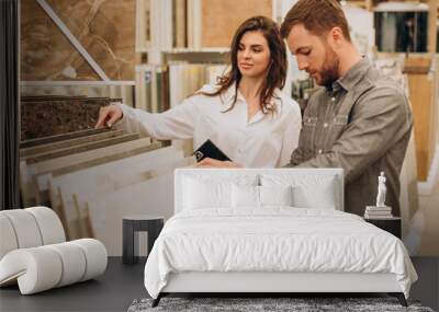 Young couple choosing tiles at building market Wall mural