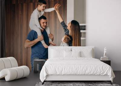 Young family with their little son at home having fun Wall mural