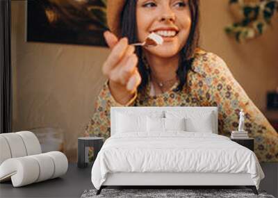 Young woman eating delicious tiramisu in a cafe Wall mural