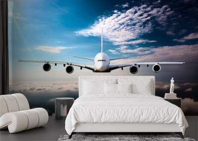 Civil wide-body plane in flight. Aircraft flying on a high altitude above the clouds. Airplane front view. Wall mural