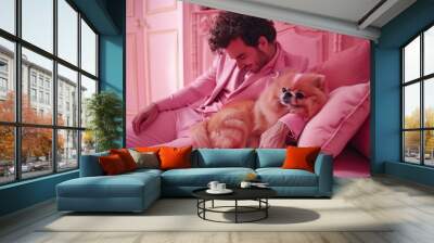 man in pink suit holding pink  pomeranian dog in luxury room
 Wall mural