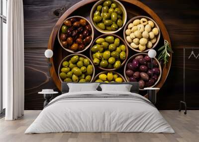 Assortment of fresh olives with different colors in bowls with rosemary branches on wooden background. Top view. Wall mural