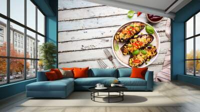 Baked aubergines boats, stuffed with minced meat, tomatoes, corn, garlic and cheese in white plate, top view Wall mural