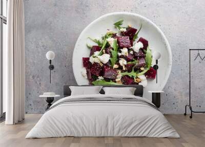 beetroot salad with blue cheese, arugula and walnut in a white plate on gray background, top view Wall mural