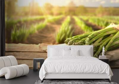 Fresh Asparagus on Farm Wooden Table, Freshly harvested green asparagus arranged on a rustic wooden table, with a softly blurred farm landscape in the background. Wall mural