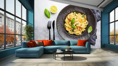 Italian pasta fettuccine in a creamy sauce with shrimp on a black plate, top view Wall mural