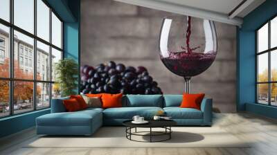 Pouring red wine into the glass against wooden background Wall mural