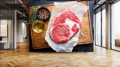 Raw fresh meat Ribeye Steak and seasonings on dark background, top view with copy space Wall mural