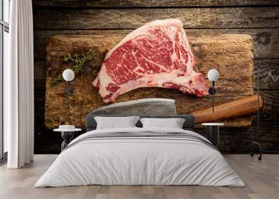 Raw fresh meat T-bone beef Steak and butcher knife on wooden background, top view Wall mural