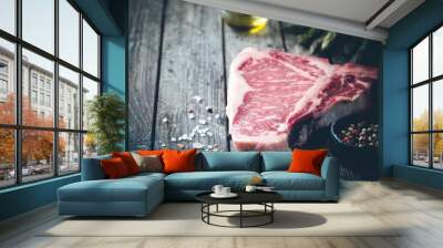 Raw T-bone Steak with fresh herbs and oil on dark wooden background Wall mural