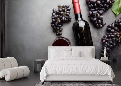 Red wine in a glass and ripe grapes on gray background, top view Wall mural