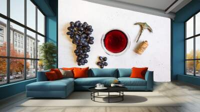 Red wine in a glass and ripe grapes on white background, top view Wall mural