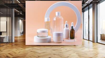 Set of natural cosmetics for face care serum, cream and micellar water on spesial podium pastel blurred background Wall mural