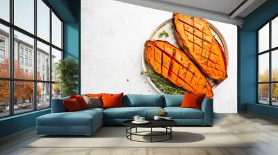 Two halves of baked yam sweet potato with spices and herbs, top view Wall mural