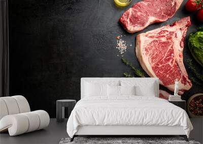 Variety of Fresh Raw Black Angus Prime Meat Steaks T-bone, New York, Ribeye and seasoning on black background, top view Wall mural