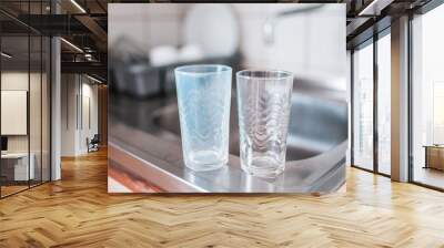 Dirty and clean glass cups on a kitchen sink. Broken washing machine concept. Wall mural