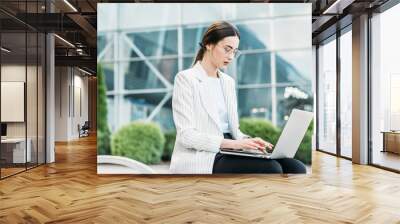 Successful businessman working at laptop. Business woman working. Sales woman working using her laptop while writing text. Businesswoman in glasses working on-line. Mobile technology. Wall mural