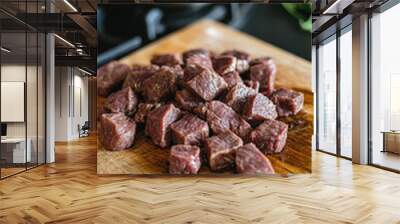 Freshly diced thick beef slices on wooden cutting board, ready for cooking. rich color and texture of meat highlight its quality, perfect for hearty meal Wall mural