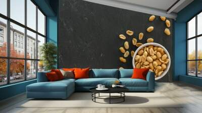 bowl with roasted and salted peanuts on a slate with copy space Wall mural