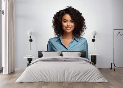 professional African American woman with a friendly smile, curly hair, wearing a blue blouse, against a light grey background, looking confident and approachable. Wall mural