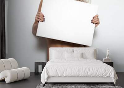 Your text here. Pretty young excited woman holding empty blank board.Portrait with white background. Sexy naked blonde holding empty board.Beauty blonde wearing lingerie with empty board Wall mural